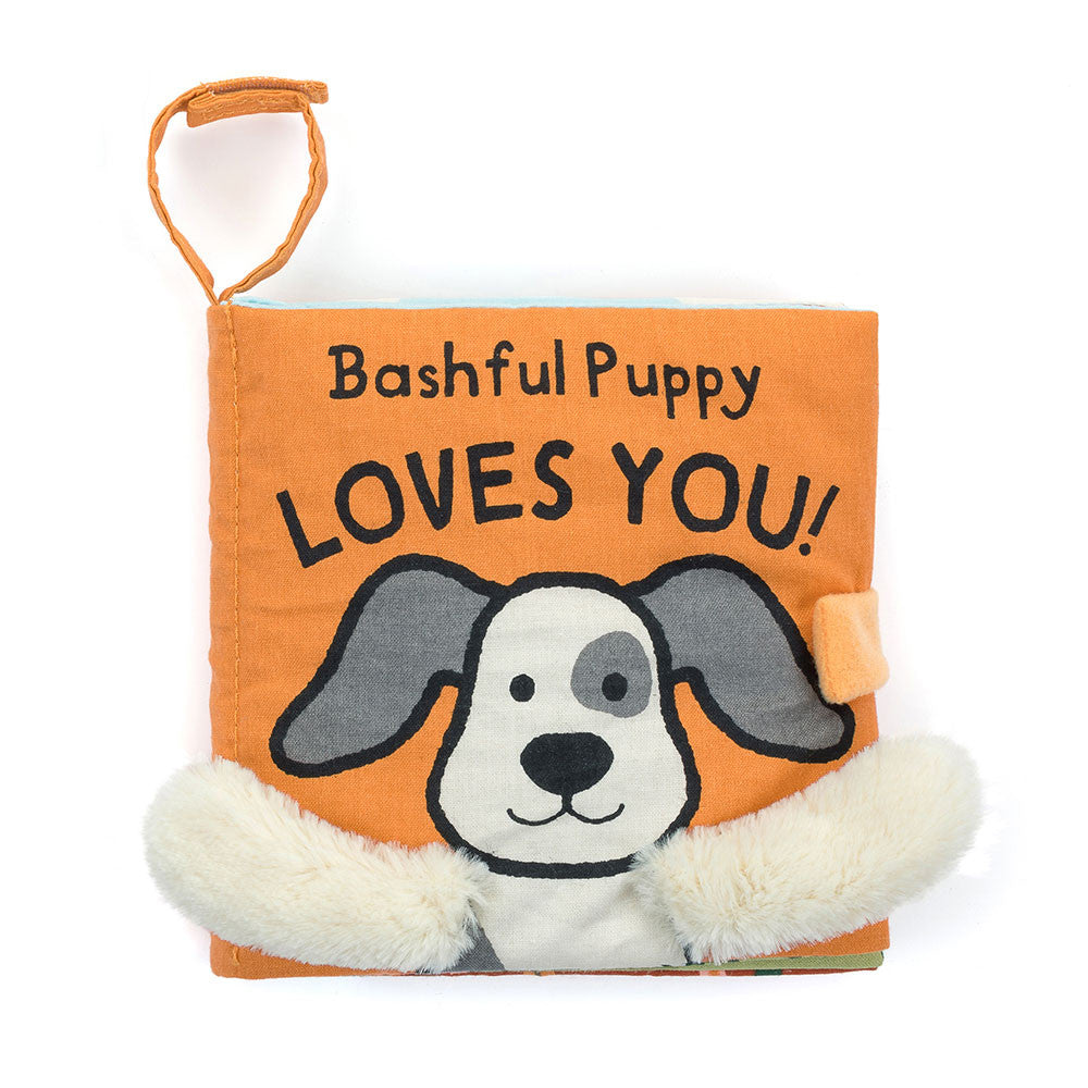 A soft fabric baby book with a puppy on the cover and fuzzy white arms, titled "Bashful Puppy LOVES YOU!"