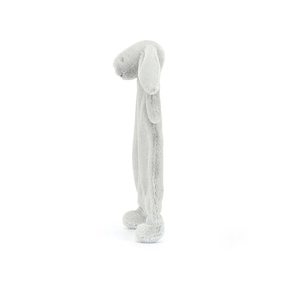 A side view of a silver plush bunny comforter with long floppy ears, stitched facial features, and a flat blanket-style body with lightly padded arms and feet, positioned standing against a white background.