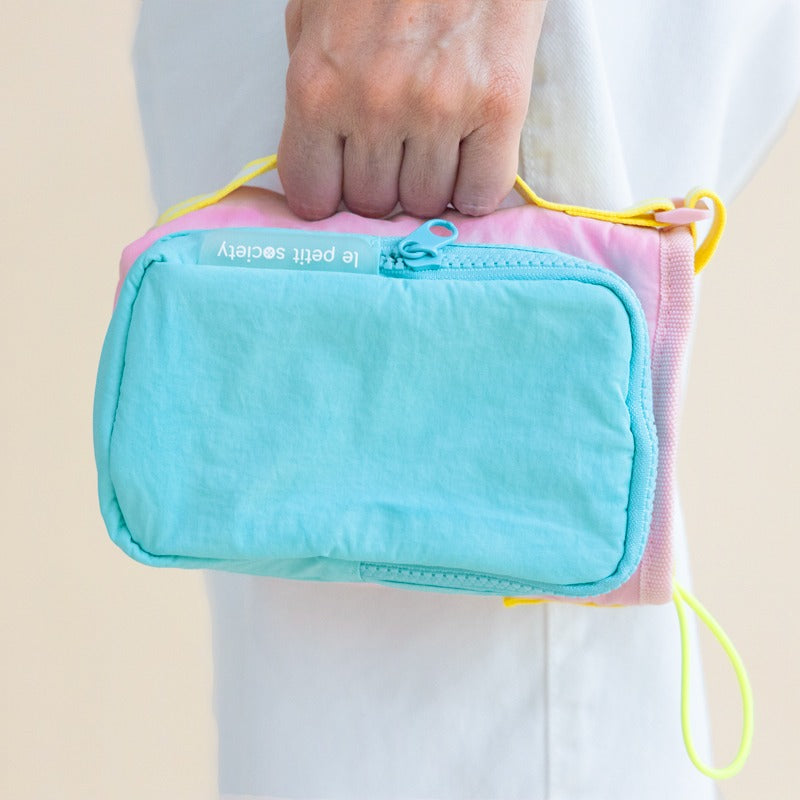 A hand carrying a water bottle bag with a side handle.