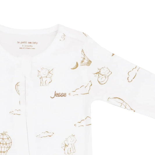 A close-up of a name embroidery personalisation on an organic zip sleepsuit in dragon print by Le Petit Society.