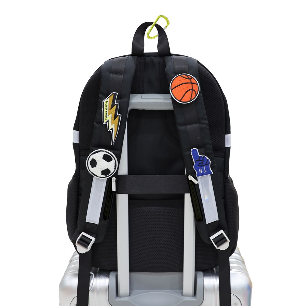 The shoulder straps of the school bag are personalised with sticker patches.