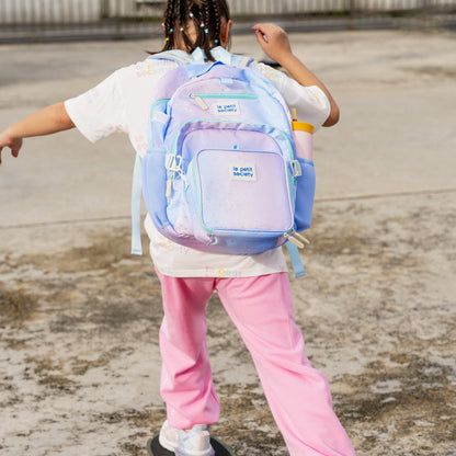A primary school girl carrying the LPS kids single pocket school bag in an ombre galaxy design.