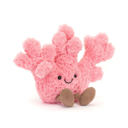 A front view of a soft pink plush coral toy  with textured branches, a happy stitched face, and brown corduroy feet
