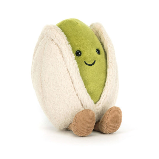 A front view of a plush pistachio toy with a smiling green center and soft beige shell, featuring corduroy-style brown feet.