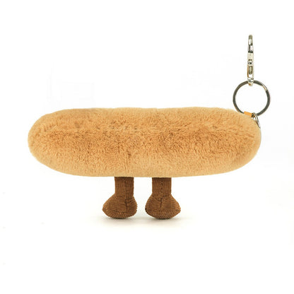 A back view of a plush baguette keychain with embroidered smile, soft brown legs, and corduroy accents, complete with a silver clip for easy attachment.