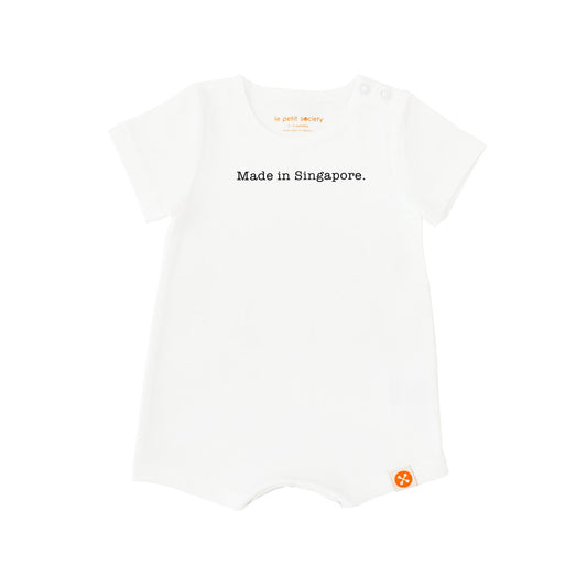 A simple white baby romper from Le Petit Society with a text at the front that says, "Made in Singapore." 