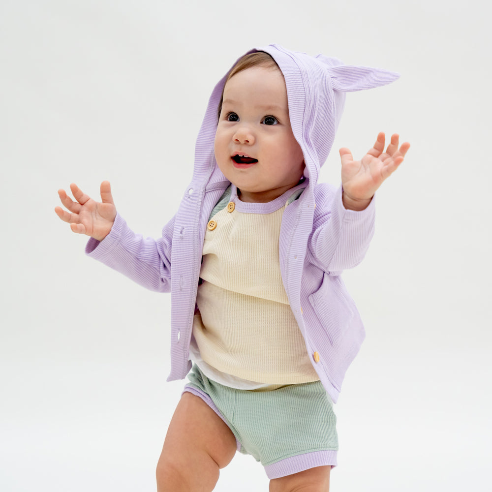 A baby boy wearing a set of boxers and raglan tee in a matching pastel colour scheme