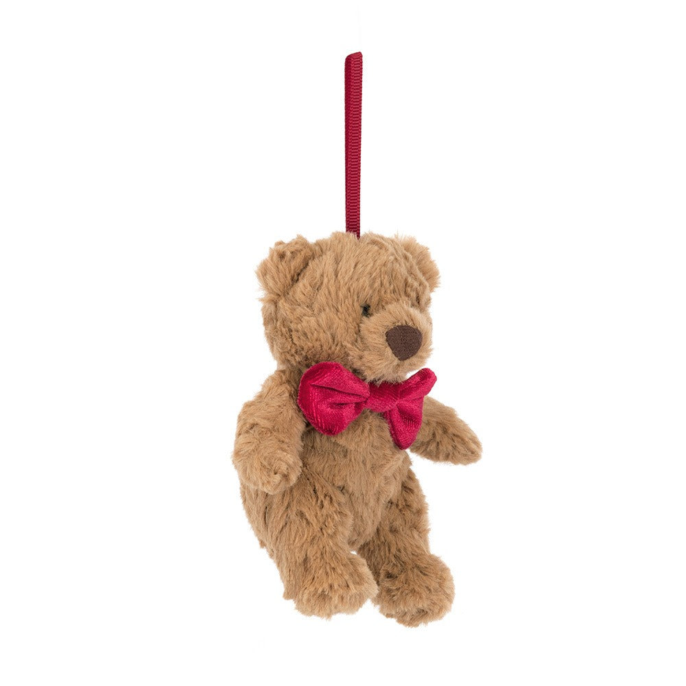 A 45 degree view of a Small plush teddy bear ornament with soft brown fur, wearing a red bow tie and hanging from a red ribbon loop, perfect for decorating a Christmas tree or gift.