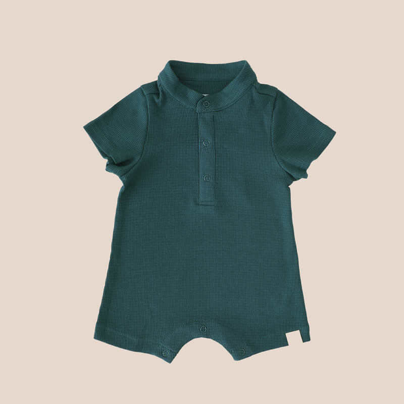 A rib knit baby romper in forest green from Le Petit Society.