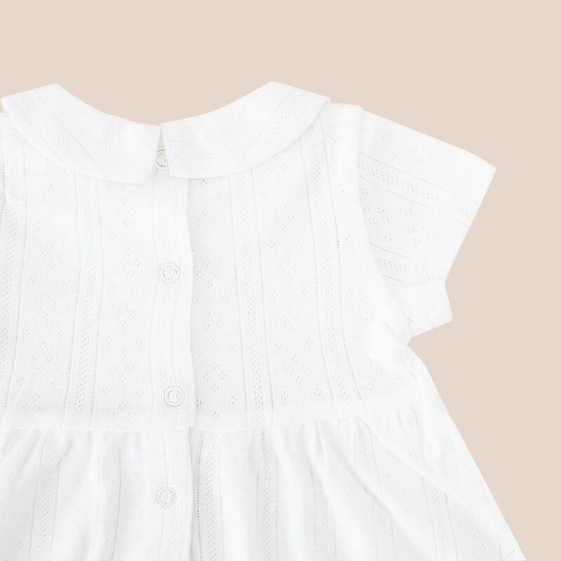 A white pointelle cotton dress with a peter pan collar from Le Petit Society. It also comes with snap buttons at the back for easy changing.