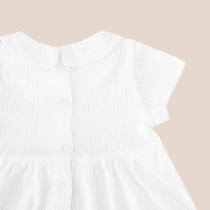 A white pointelle cotton dress with a peter pan collar from Le Petit Society. It also comes with snap buttons at the back for easy changing.