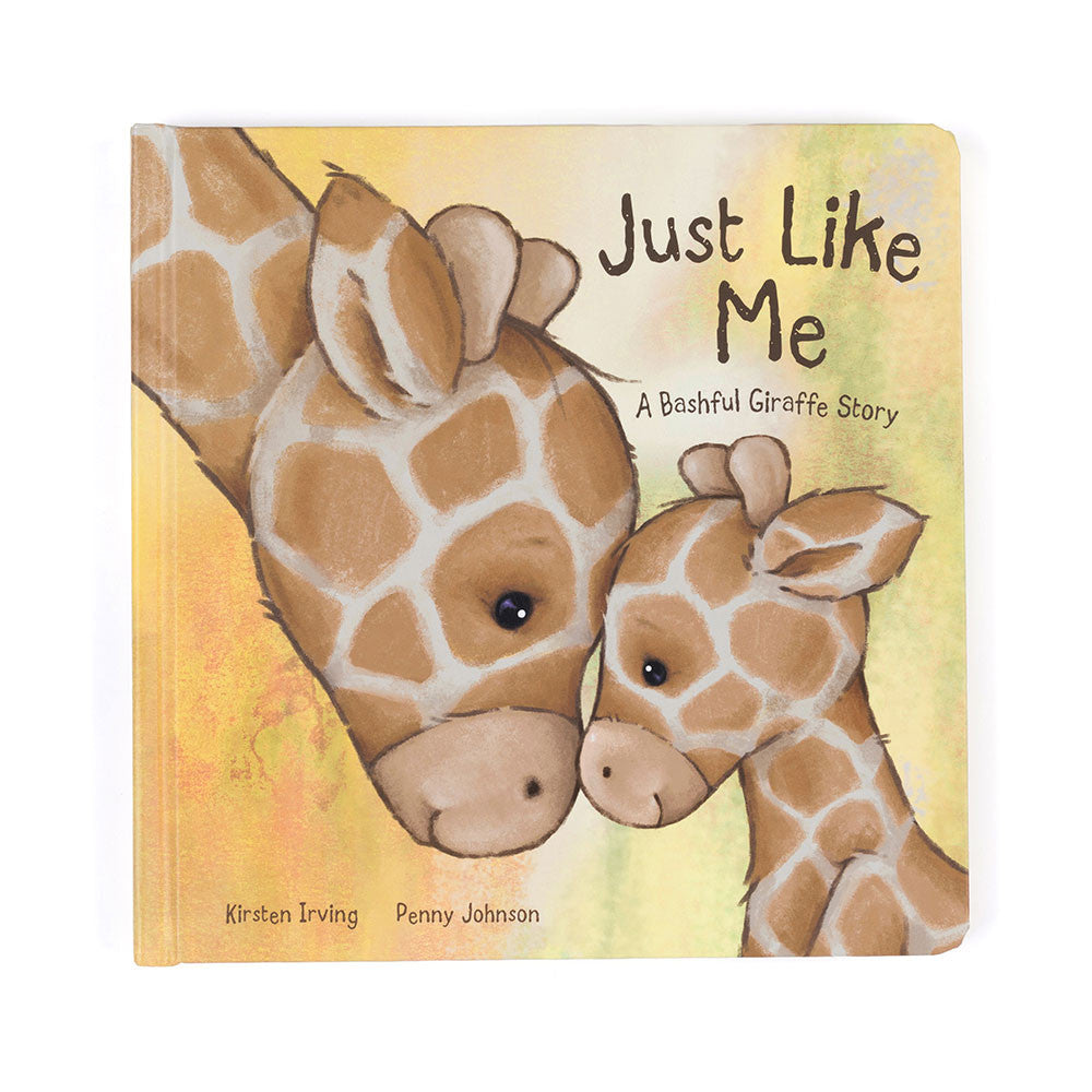 Book cover titled "Just Like Me: A Bashful Giraffe Story" shows a close-up of two giraffes touching noses affectionately. The background is soft yellow and green, with authors Kirsten Irving and Penny Johnson credited below.