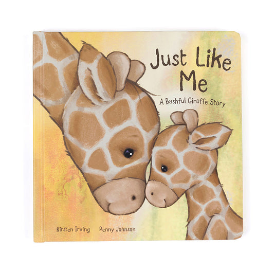 Book cover titled "Just Like Me: A Bashful Giraffe Story" shows a close-up of two giraffes touching noses affectionately. The background is soft yellow and green, with authors Kirsten Irving and Penny Johnson credited below.