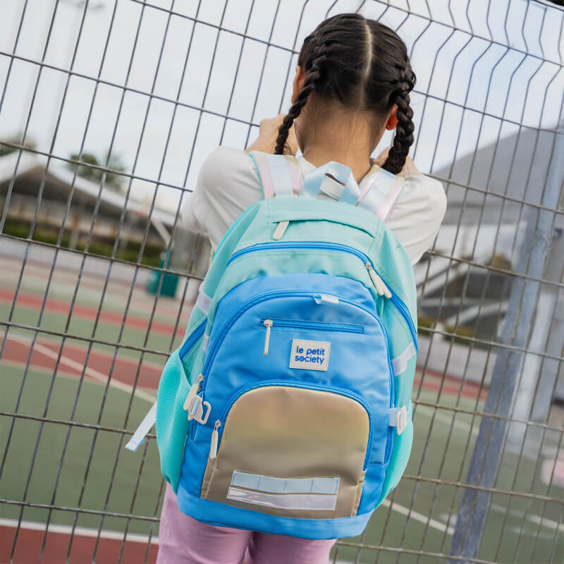 A primary school bag carrying the LPS kids double pocket school bag in blue and silver.