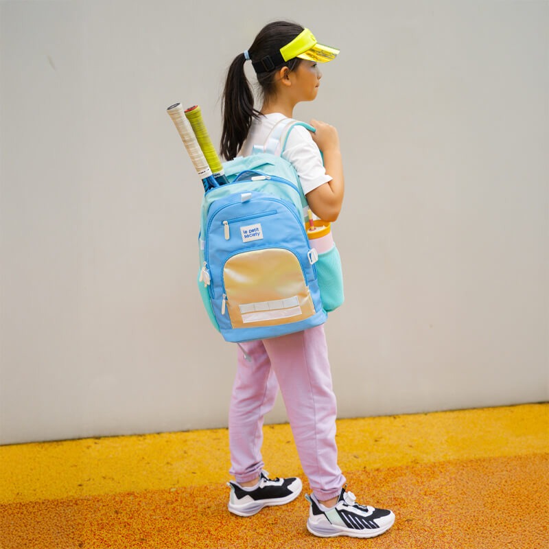 A primary school girl carrying her sports equipments in the LPS kids double pocket school bag.