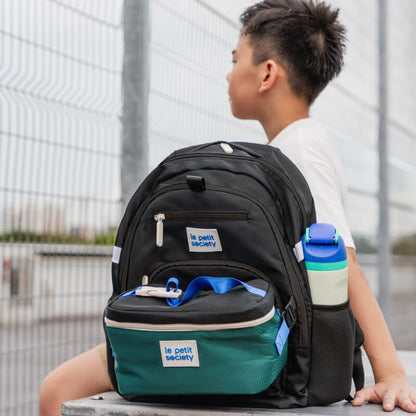 A primary school boy carrying the LPS double pocket school bag in cool black.