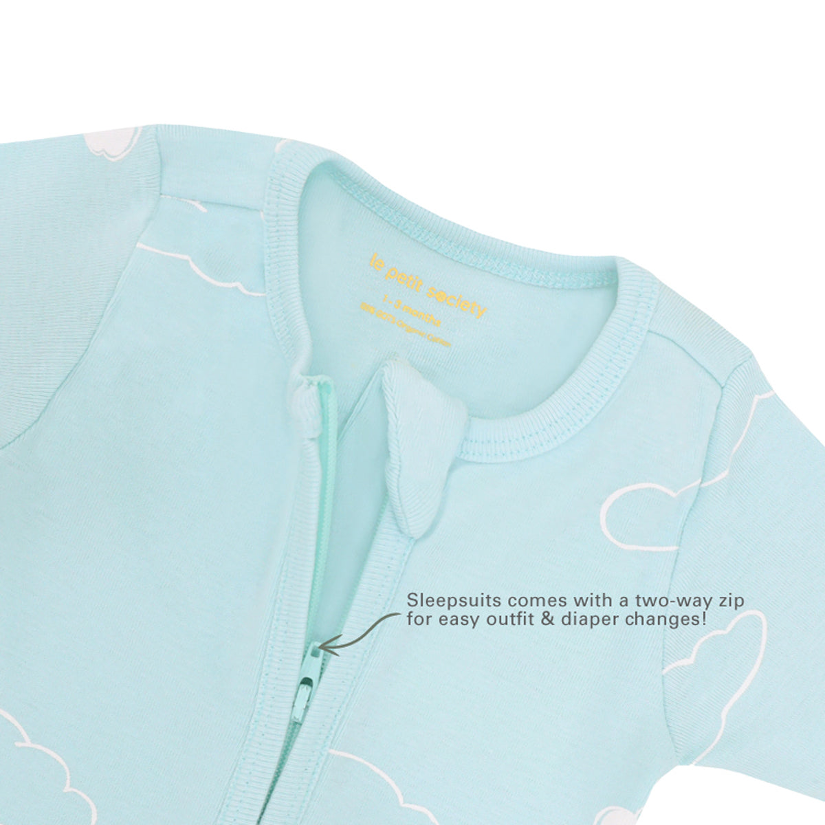 Infographic indicating the two-way zip of Le Petit Society's organic baby sleepsuit and its purpose of providing easy outfit and diaper changes.