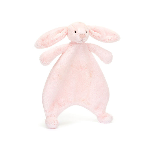A front view of a soft pink plush bunny comforter with long floppy ears, stitched facial features, and a flat blanket-style body with lightly padded arms and feet, positioned standing against a white background.