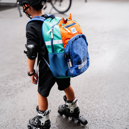 A sporty primary school boy roller skating while carrying the LPS kids single pocket school bag.