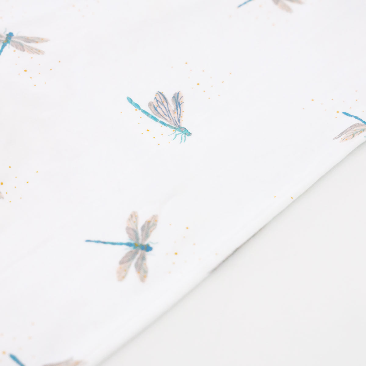 A close-up of the dragonfly print of Le Petit Society's organic zip sleepsuit.