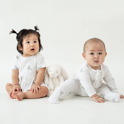 Two babies wearing pieces from Le Petit Society's organic baby line in dragonfly print. 