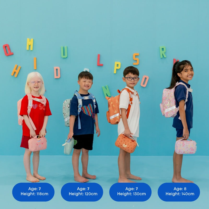 Four primary school kids carrying school bags and pencil cases by Le Petit Society.