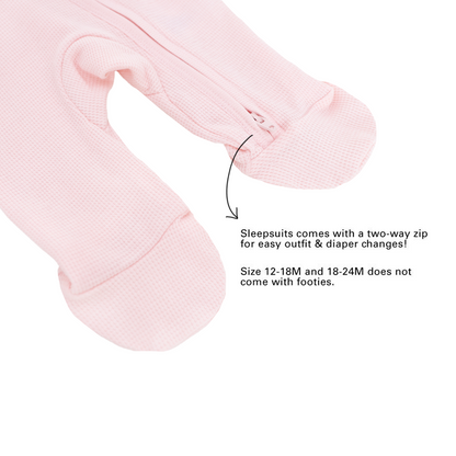 An infographic demonstrating the two-way zipper and lack of footies for size 12-18M and 18-24M of an organic baby sleepsuit in pink by Le Petit Society.
