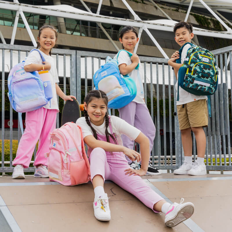 A group of primary kids carrying school bags from Le Petit Society.