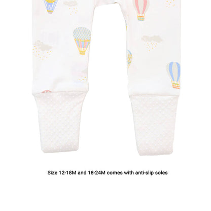 An infographic demonstrating the anti-slip soles of the sizes 12-18M and 18-24M of Le Petit Society's organic zip sleepsuit in hot air balloon print.
