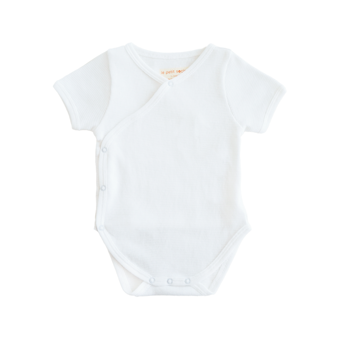 An organic, short-sleeved, kimono baby romper in white by Le Petit Society.