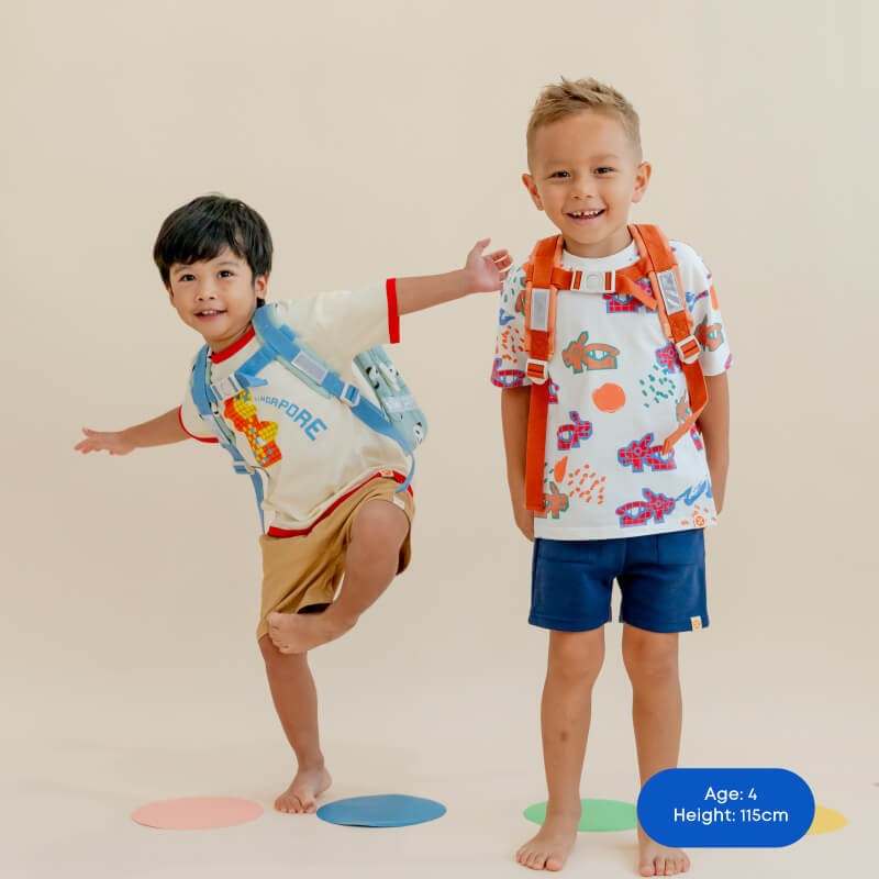 Two preschool boys wearing school bags and tees from Le Petit Society.