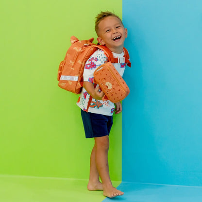 Preschool boy smiling while carrying an orange school bag and pencil case in tiger design.