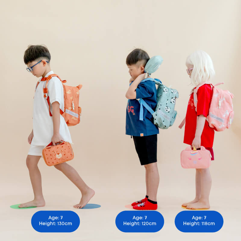 Three primary school kids carrying school bags and pencil cases by Le Petit Society.