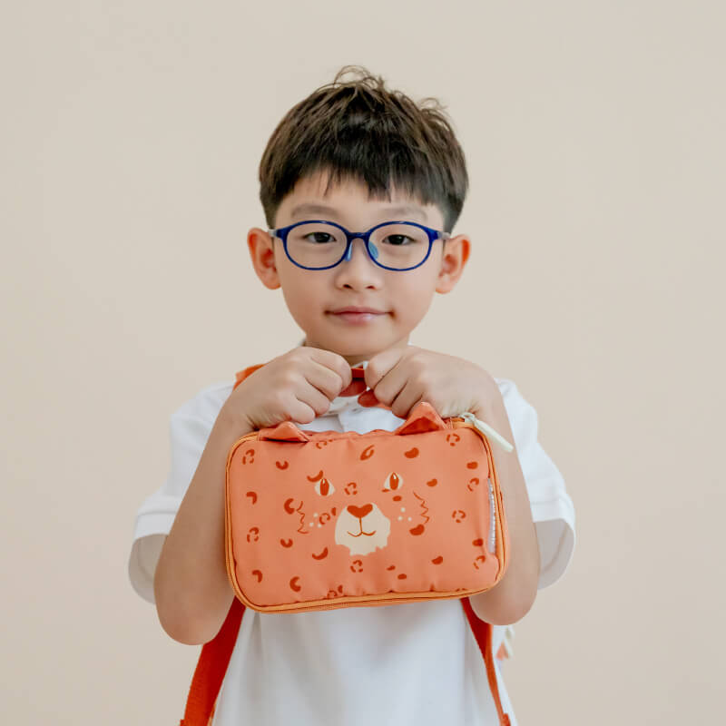 A kindergartener with an orange Explorer pencil case and pouch in leopard print.