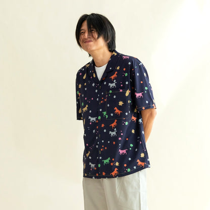 A man wearing the men’s Rainbow Horse shirt stands with a cheerful, slightly playful smile. The colourful horse and confetti motifs pop vividly against the navy fabric, giving the look a fun and easygoing charm.