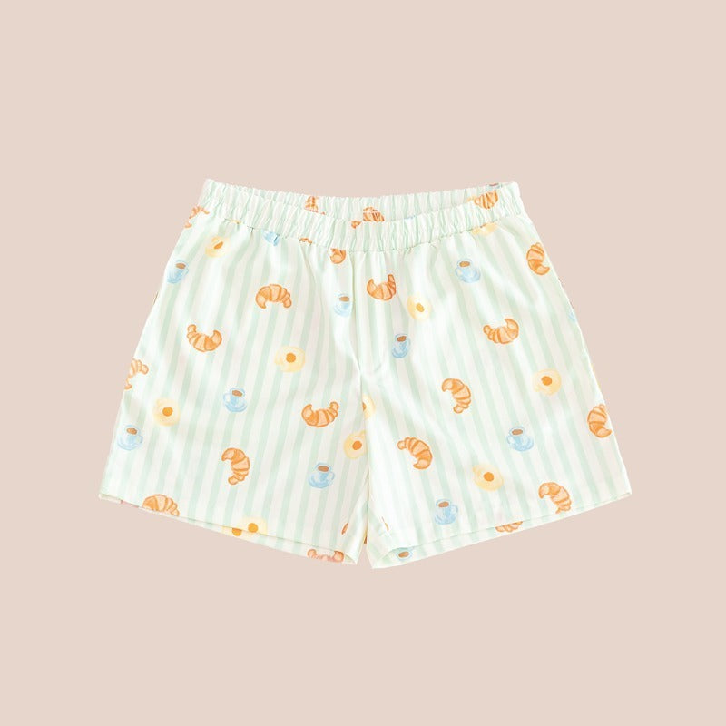 A pair of men's lounge shorts featuring a print of breakfast food and pastel green stripes, from Le Petit Society.