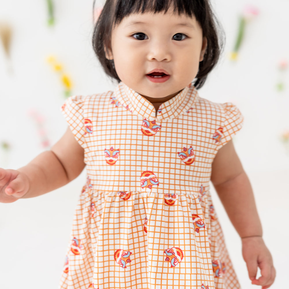 Lion Dance Series - Baby Girl Jersey Dress in Orange Grid Print (Personalisable) by Le Petit Society — image 2