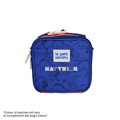 A blue and orange thermal lunch bag with a dinosaur print and personalised name patches.