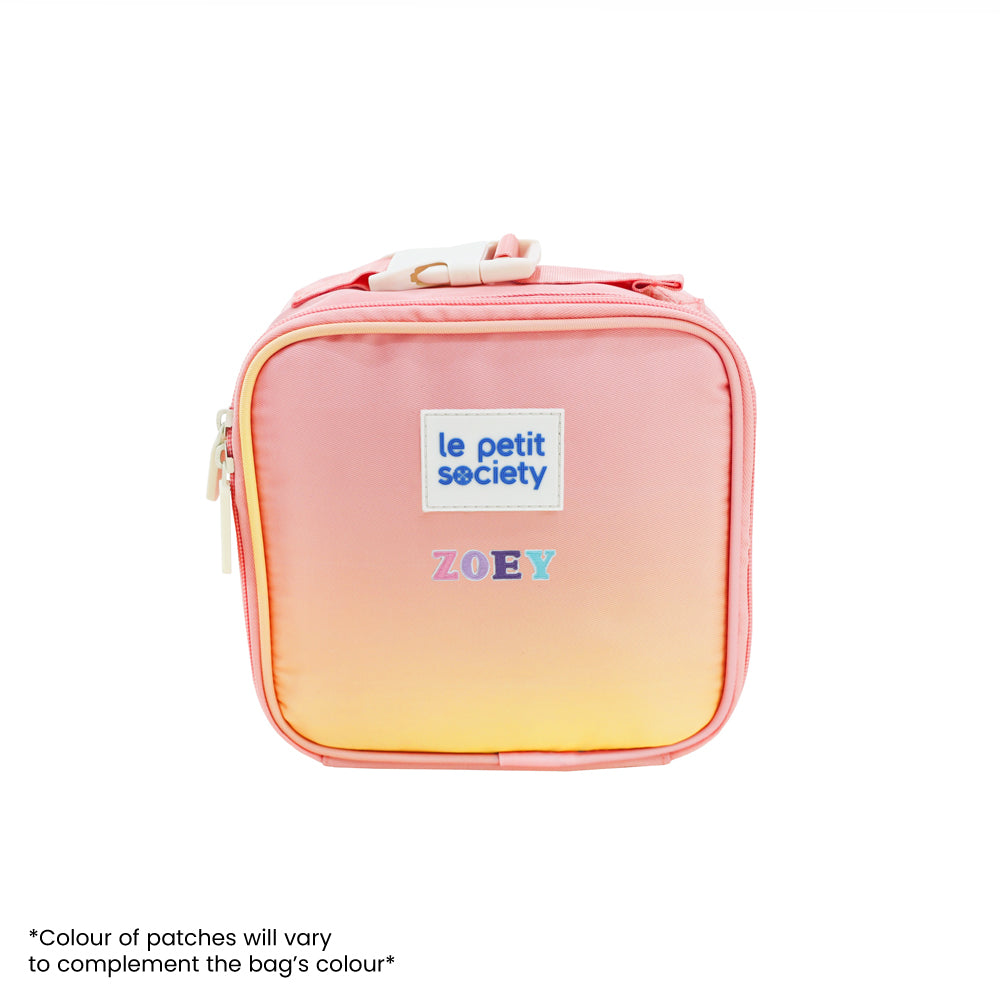 An ombre, pink and yellow thermal mini lunch bag with personalised name patches.