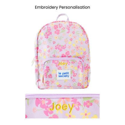 A purple preschool bag with a floral print and personalised name embroidery.