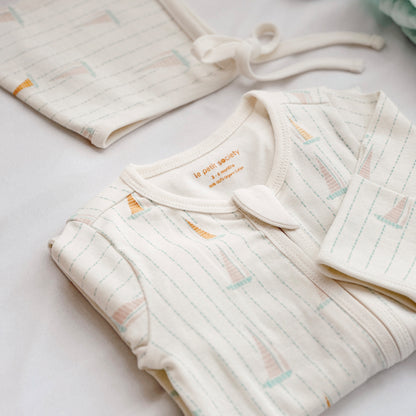 A close-up of an organic baby zip sleepsuit in sail boat print from Le Petit Society.