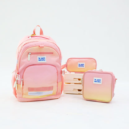 The LPS kids essential school bundle in a pink and yellow ombre, consisting of a school bag, mini lunch bag and pencil case.