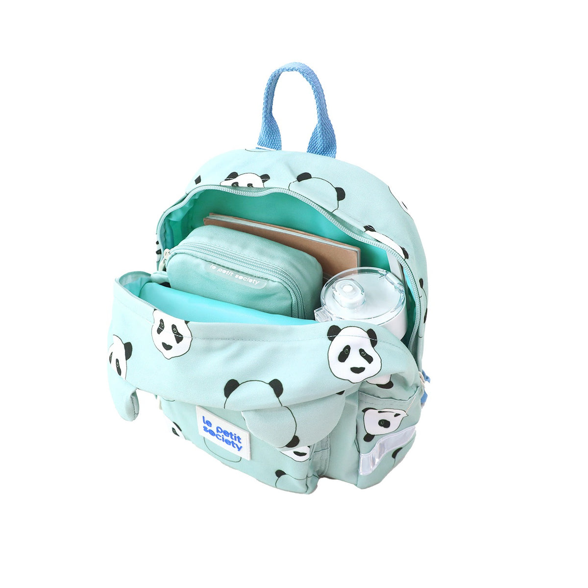 A pencil case, water bottle and notebook being stored in a mint green preschool bag.