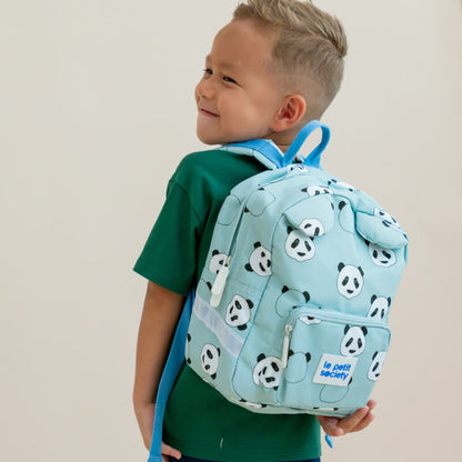 A toddler boy carrying a mint green school bag with a panda print.