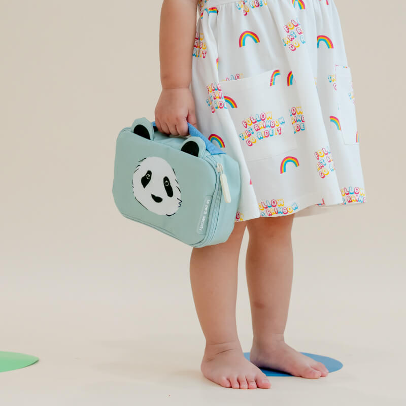 A toddler carrying a mint blue pencil case and pouch with a panda print and a pair of ears.