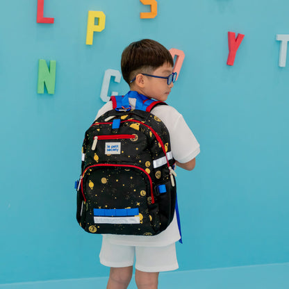 A primary school boy carrying the LPS kids single pocket school bag in planet print.