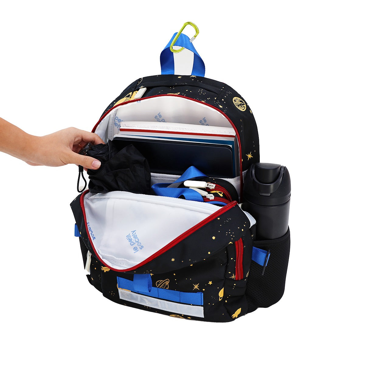 An umbrella, pencil case and several school books being stored in the kids single pocket school bag.