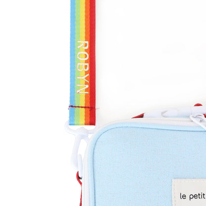 A close-up of a personalised name embroidery on a rainbow bag strap of a thermal lunch bag from Le Petit Society.