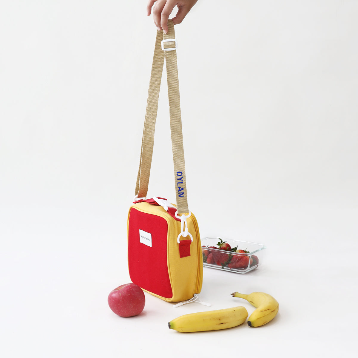 The strap of a thermal lunch bag personalised with name embroidery, from Le Petit Society.