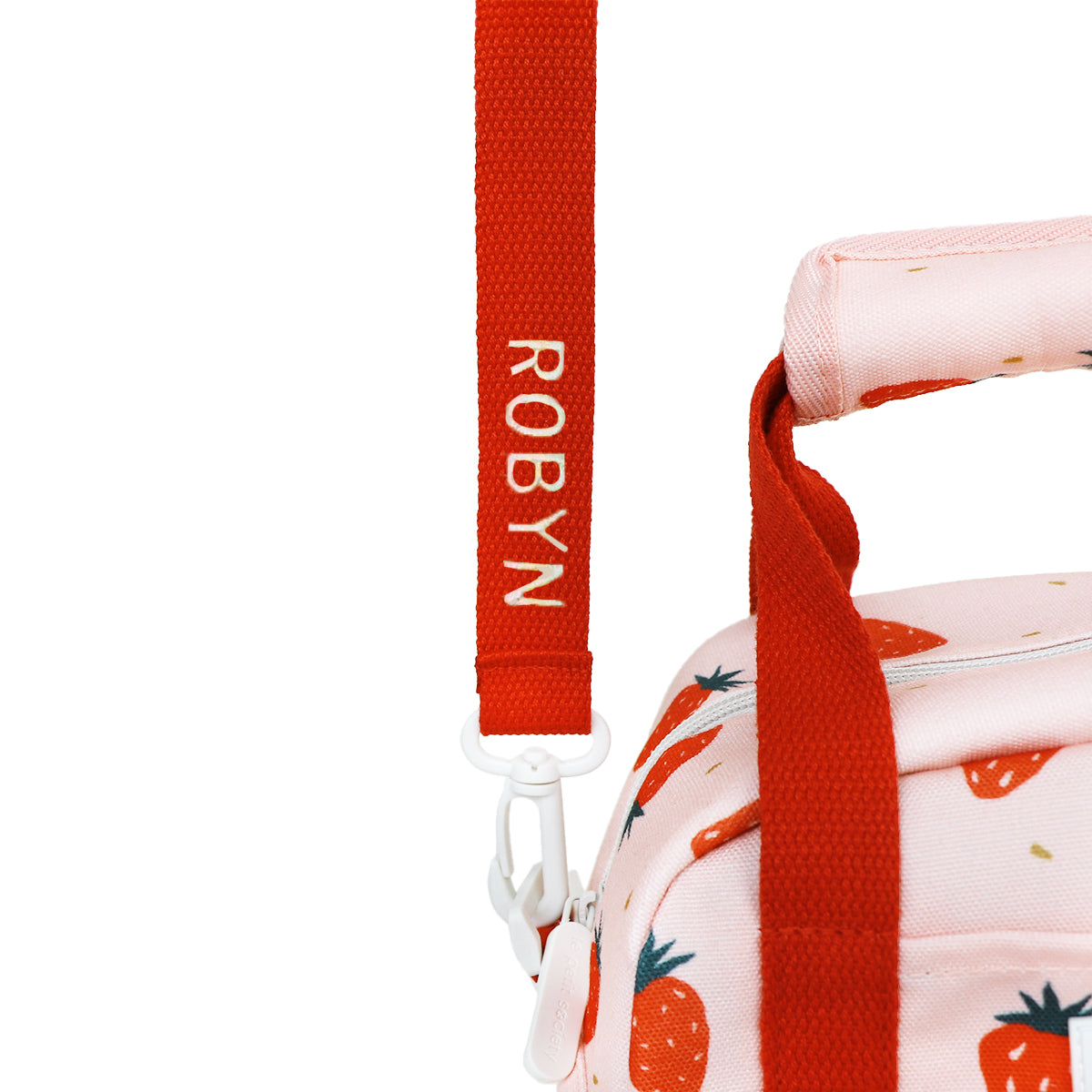 A close-up of a personalised name embroidery on a red bag strap of Le Petit Society's thermal lunch bag.